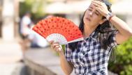 Una mujer abanicándose por el calor.
