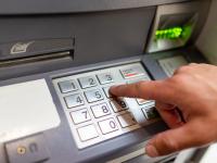 Una persona introduciendo un código PIN en el cajero
