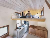 Una pareja, en una cama elevada, en un estrecho minipiso.