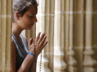 Una joven reza en una iglesia