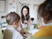 Una profesora de infantil dando clase a niños pequeños