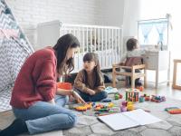 Una madre y sus dos hijas jugando en la habitación de los niños.