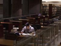 Un joven estudiando en una biblioteca, en una imagen de archivo