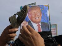 Un simpatizante hutí apunta con su sandalia a un póster del presidente de EEUU, Donald Trump, en Saná (Yemen), el 16 de junio de 2026. En el mundo árabe, es un insulto de peso.