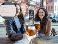 Grupo de mujeres brindando con cerveza en la soleada terraza de un bar