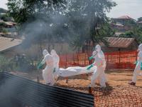 Un cuerpo es trasladado a la morgue del Centro Médico Nyankunde para los procedimientos de entierro por equipos de salud que visten trajes de protección como parte de las medidas de control de la epidemia.