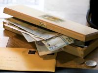Una caja de madera llena de billetes y monedas