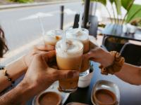 Un grupo de varias personas brindando con un café.