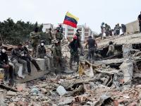 Los equipos de rescate colocan una bandera de Venezuela sobre los escombros, tras el doble terremoto sufrido por el país, el 28 de junio de 2026, en Caracas.