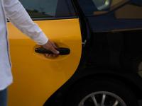 Una persona cerrando una puerta de un taxi en Barcelona.