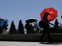 Varias personas protegiéndose del sol en Madrid