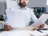 Un empleado leyendo varios documentos