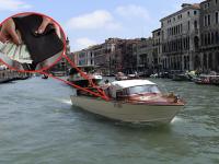 Una imagen de archivo de un vaporetto navegando por un canal de Venecia y otra de una cartera con dinero