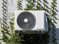 Un aparatos de aire acondicionado por encima de unas plantas