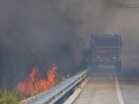 Un camión de bomberos pasando al lado de un incendio