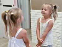 Una niña mirándose en un espejo, en una imagen de archivo