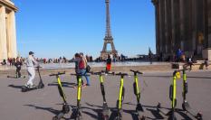 Patinetes eléctricos en París estacionados en la Plaza de Trocadero con la Torre Eiffel al fondo.