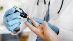 Un sanitario mide la cantidad de azúcar en sangre a un paciente.