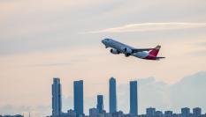 Un vuelo de Iberia despega desde el aeropuerto de Madrid, con las cuatro torres al fondo.