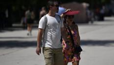 Dos turistas se protegen del calor de finales de junio en Madrid