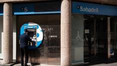 Un hombre retira dinero de un cajero.