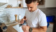 Un hombre se prepara un batido proteínico antes de entrenar.