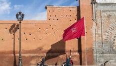 Un bandera de Marruecos ondea junto a parte de la muralla de la ciudad antigua de Marrakech.
