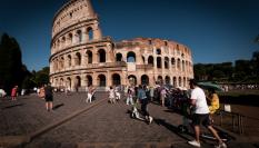 Turistas pasan por delante el Coliseo de Roma.