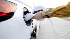 Una persona carga un coche eléctrico.