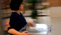 Una mujer lleva una urna vacía