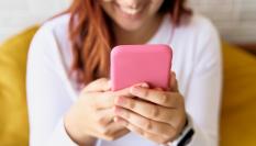 Una mujer con un móvil rosa.