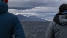 Dos personas observan el Atlántico desde la costa argentina.