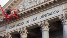 Un operario trabaja en la fachada del Congreso de los Diputados.