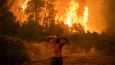 Un vecino observa asombrado el fuego en uno de los muchos rincones afectados de Grecia