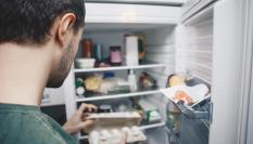 Un hombre abriendo un frigorífico.