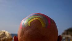 Un hombre calvo luce un arcoíris