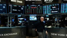 Un corredor de bolsa atraviesa el parqué de Wall Street.