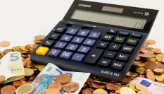 Billetes y monedas de euro junto a una calculadora