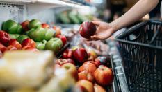 Imagen de archivo de una persona comprando fruta en un supermercado.