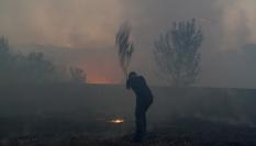 Un hombre intenta apagar el fuego con una rama en uno de los incendios que arrasan Portugal.