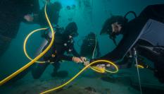 Submarinistas instalan cables en el fondo marino.