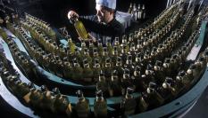 Un operario trabaja en una línea de embotellamiento de aceite de oliva.