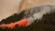 Un avión participa en las labores de extinción de incendio forestal en el municipio tinerfeño de El Rosario, muy cercano al núcleo poblacional de La Esperanza.