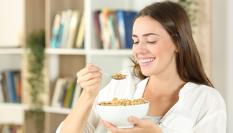 Imagen de una mujer desayunando.