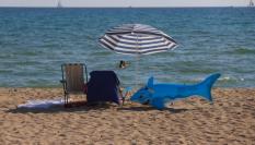 Un flotador con forma de tiburón junto a una silla y una sombrilla de playa en Palma de Mallorca en una foto de 2020.