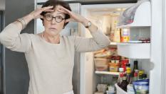 Imagen de archivo de una mujer sorprendida ante la nevera.