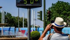 Foto de archivo de una persona haciendo una fotografía a un termómetro de Sevilla.