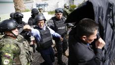 Christian Zurita, escoltado a su salida de un colegio electoral el día de las elecciones presidenciales en Ecuador.