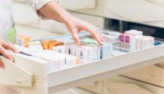 Una farmacéutica recoge varios medicamentos en el cajón de la botica.