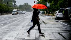 Una persona, bajo un paraguas en una lluviosa calle de Sevilla